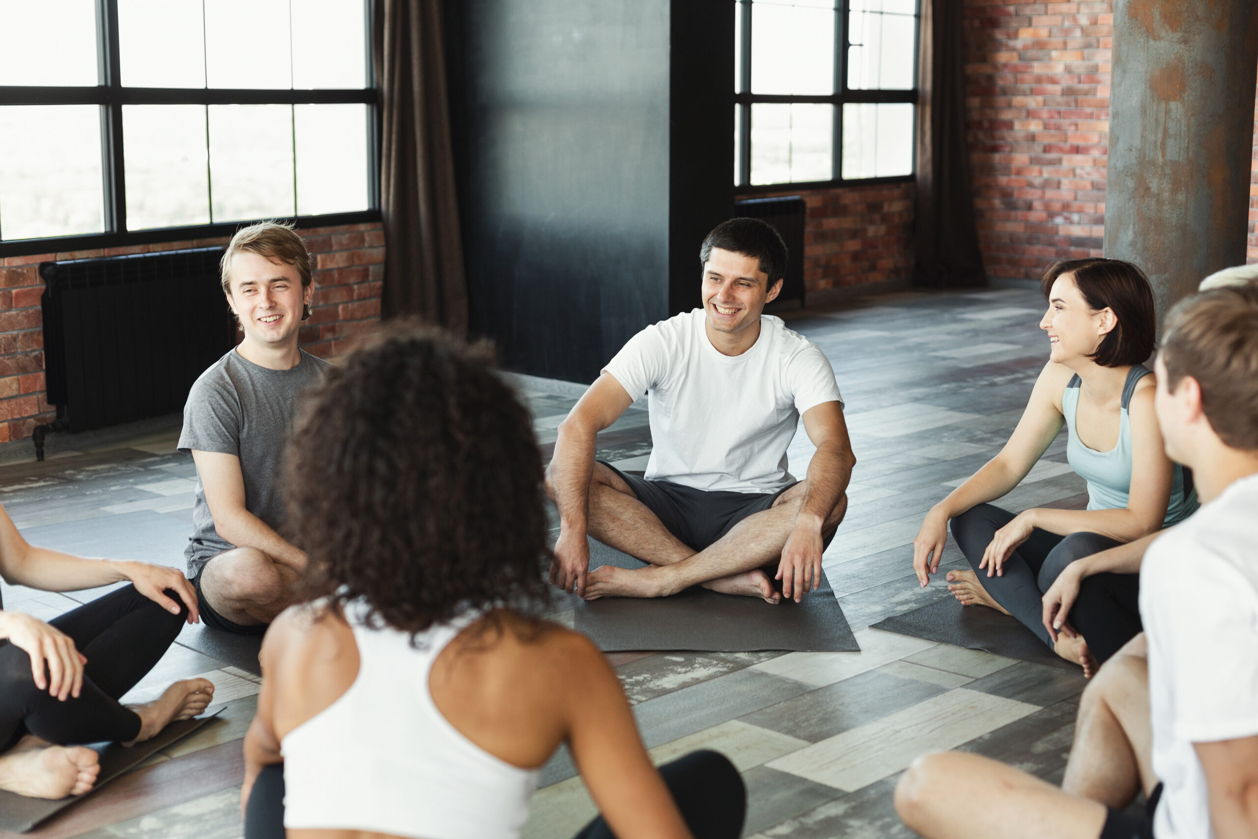 Smiling young people waiting for yoga class